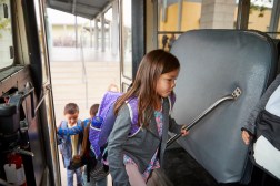 girl getting on school bus